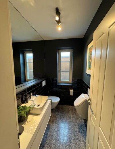 Kontrastreiche Malerarbeiten im Gäste-WC mit dunkler Wandfarbe und heller Decke in modernem Stil